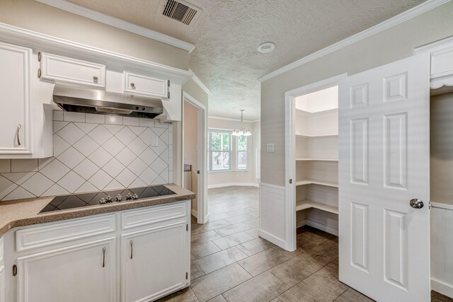 kitchen with decorative backsplash, black electric stovetop, crown molding, white cabinets, and light tile patterned flooring