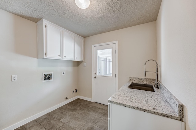 laundry area with sink, cabinets, electric dryer hookup, hookup for a gas dryer, and a textured ceiling