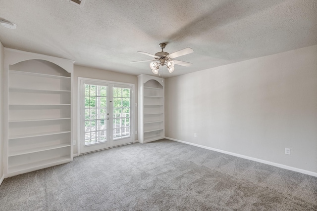 carpeted empty room featuring ceiling fan, a textured ceiling, and french doors