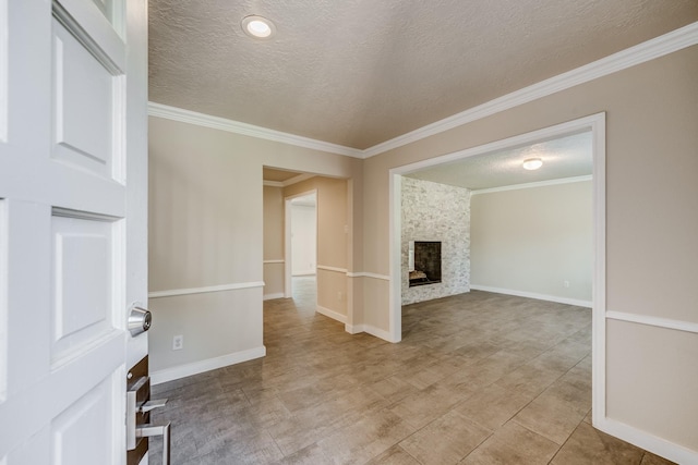 unfurnished living room with a stone fireplace, crown molding, and a textured ceiling