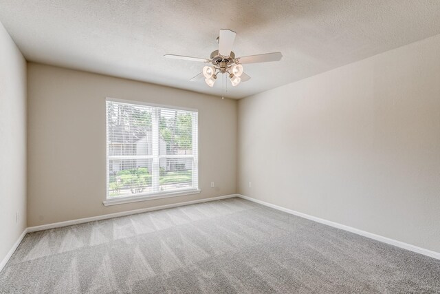 spare room with a textured ceiling, ceiling fan, and light carpet