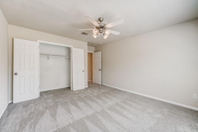 unfurnished bedroom featuring ceiling fan, light carpet, and a closet