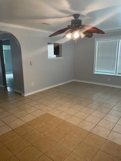 tiled spare room featuring ceiling fan and ornamental molding