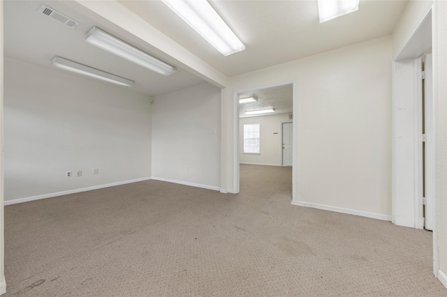 unfurnished room featuring beam ceiling and light carpet