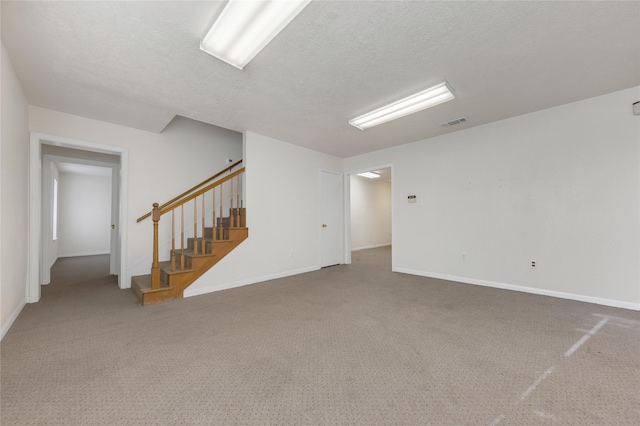 unfurnished room featuring carpet and a textured ceiling