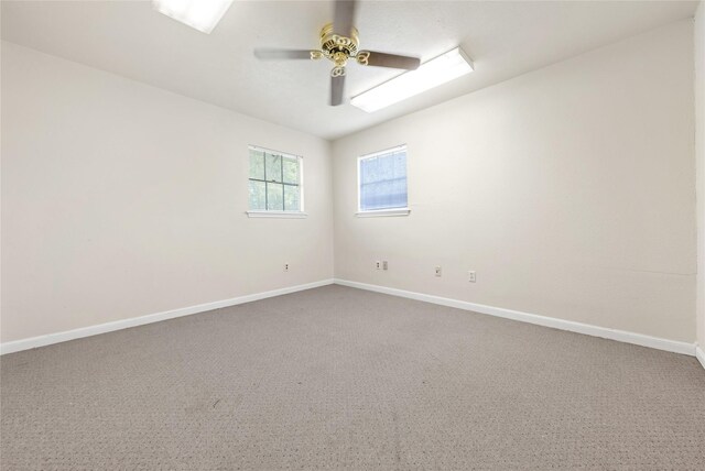 carpeted spare room featuring ceiling fan