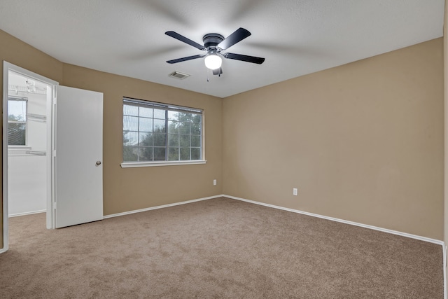 carpeted spare room featuring ceiling fan