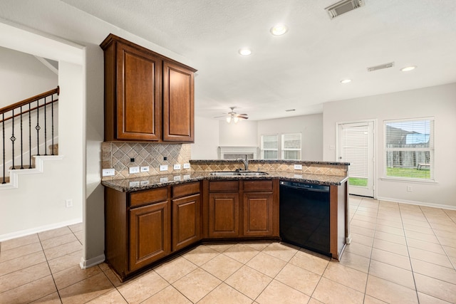 kitchen featuring dark stone countertops, light tile patterned floors, black dishwasher, and tasteful backsplash