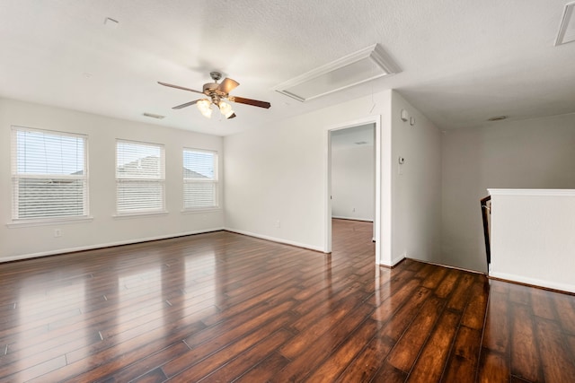 empty room with ceiling fan, dark wood-type flooring, and a textured ceiling