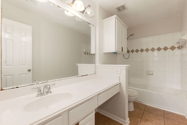 full bathroom featuring tile patterned flooring, vanity, toilet, and tiled shower / bath