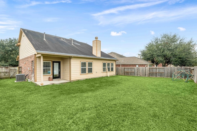 back of house with central AC, a patio area, and a lawn