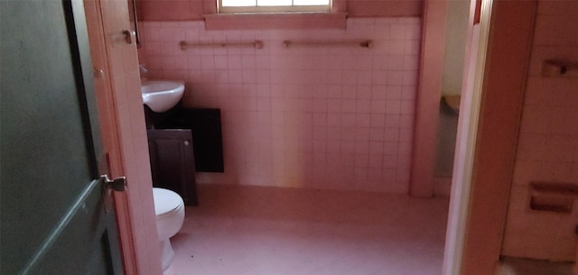 1370 Plum St, Beaumont, TX 77703 - bathroom featuring tile walls, vanity, and wainscoting