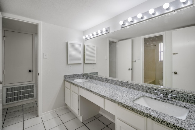 bathroom featuring vanity, tile patterned flooring, toilet, walk in shower, and a textured ceiling