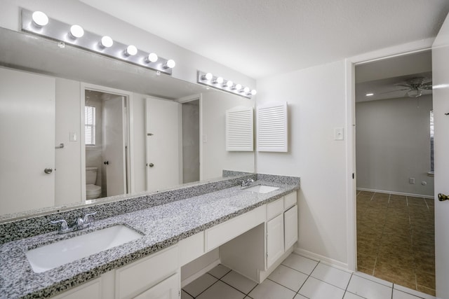 bathroom with tile patterned flooring, vanity, toilet, and ceiling fan