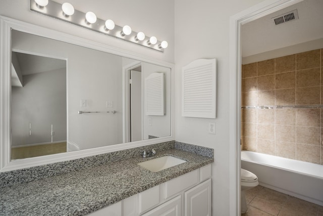 bathroom with a tub to relax in, tile patterned flooring, vanity, and toilet