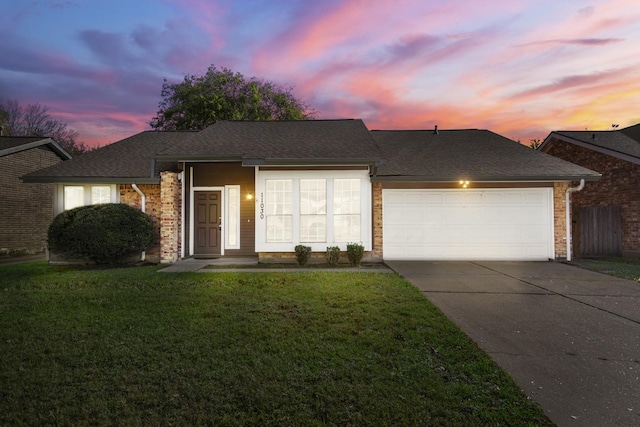 single story home featuring a lawn and a garage