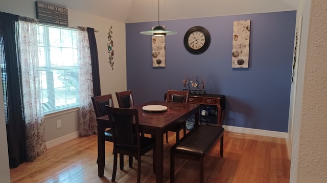 dining space featuring lofted ceiling, hardwood / wood-style flooring, and a healthy amount of sunlight