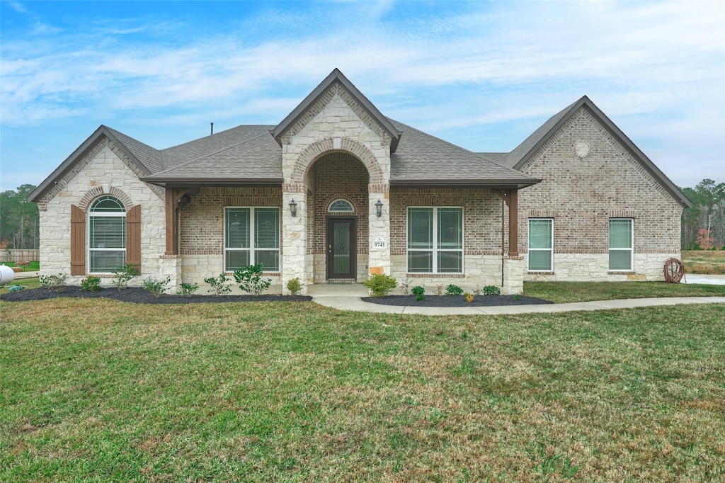 french country home featuring a front lawn