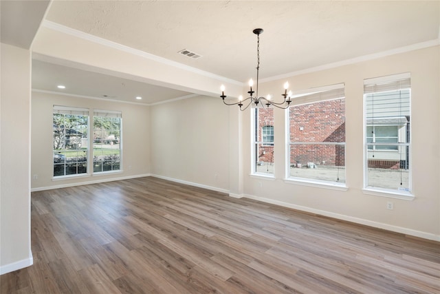 unfurnished dining area with ornamental molding, hardwood / wood-style flooring, and a notable chandelier