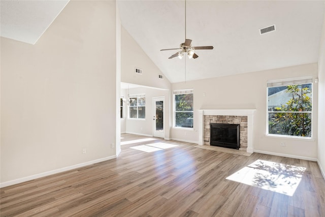 unfurnished living room featuring light hardwood / wood-style flooring, high vaulted ceiling, and a healthy amount of sunlight