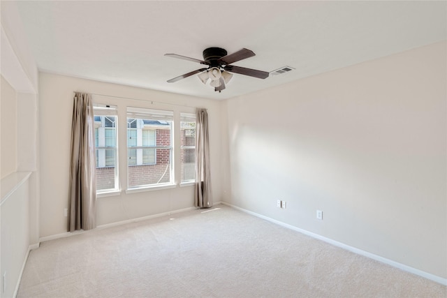 empty room featuring ceiling fan and light carpet