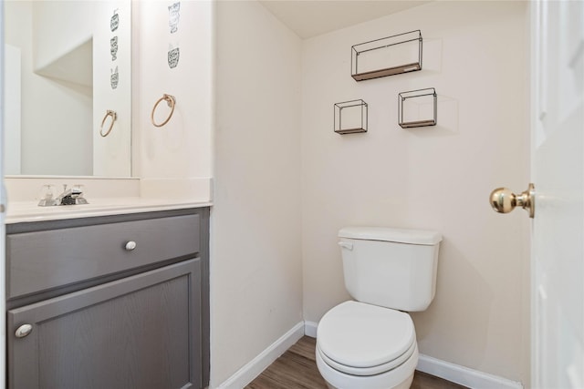 bathroom featuring toilet, vanity, and hardwood / wood-style flooring