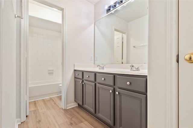 full bathroom featuring wood-type flooring, vanity, toilet, and tiled shower / bath