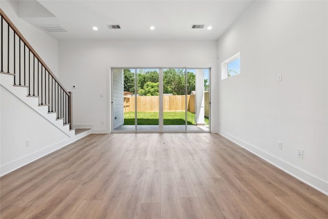 unfurnished living room featuring light wood-type flooring and a healthy amount of sunlight