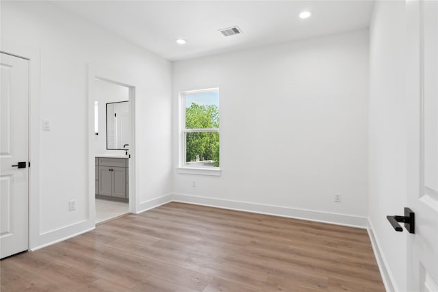 interior space with ensuite bathroom and light wood-type flooring