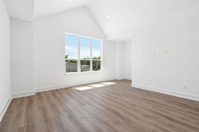 unfurnished room featuring wood-type flooring and high vaulted ceiling