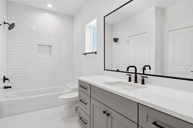 full bathroom with tile patterned floors, tiled shower / bath, vanity, and toilet