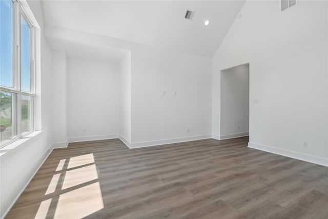 spare room with dark hardwood / wood-style flooring and high vaulted ceiling