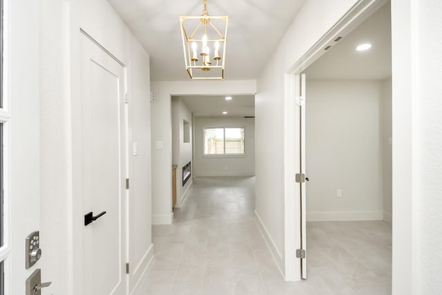 hallway with an inviting chandelier