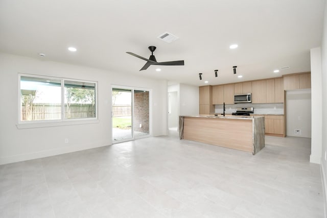 kitchen featuring ceiling fan, a healthy amount of sunlight, light brown cabinets, and appliances with stainless steel finishes