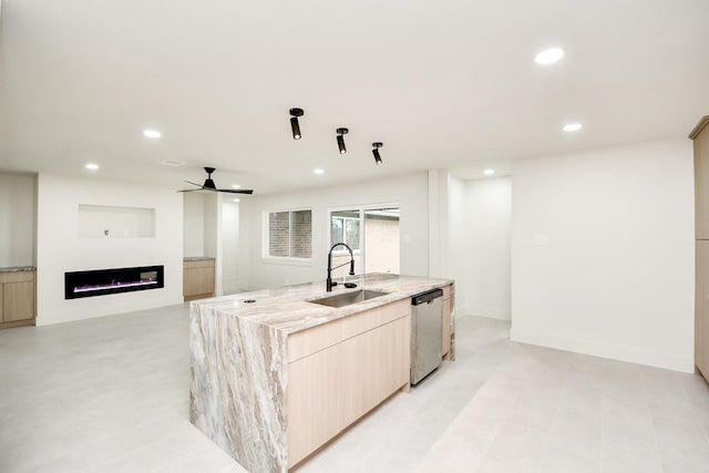 kitchen with a kitchen island with sink, sink, stainless steel dishwasher, ceiling fan, and light brown cabinetry