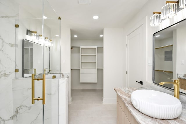 bathroom featuring tile patterned floors, vanity, and a shower with shower door