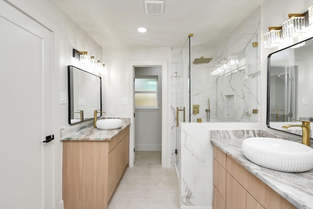 bathroom with tile patterned floors, vanity, and a shower with door