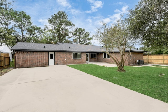 rear view of house featuring a lawn, central AC, and a patio