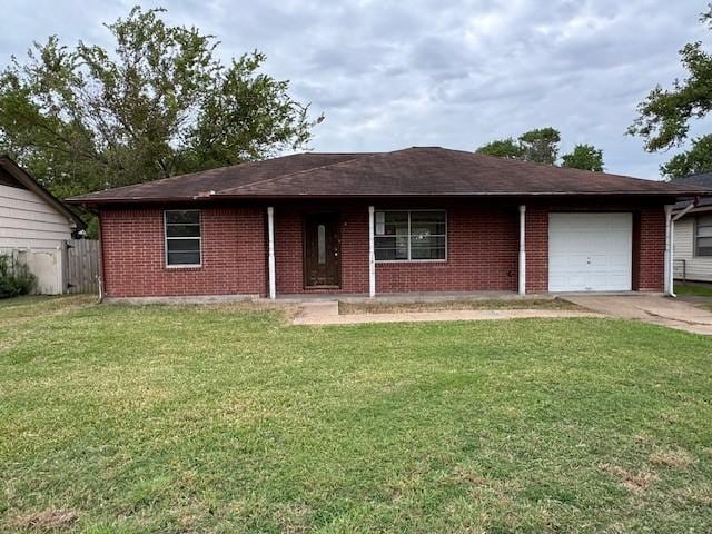 single story home featuring a garage and a front lawn