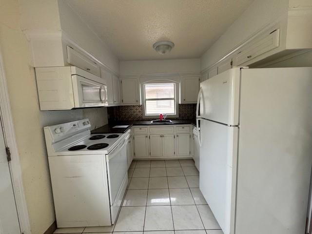 kitchen with decorative backsplash, white appliances, sink, light tile patterned floors, and white cabinets