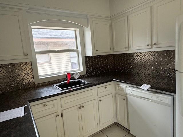 kitchen with dishwasher, white cabinetry, decorative backsplash, and sink