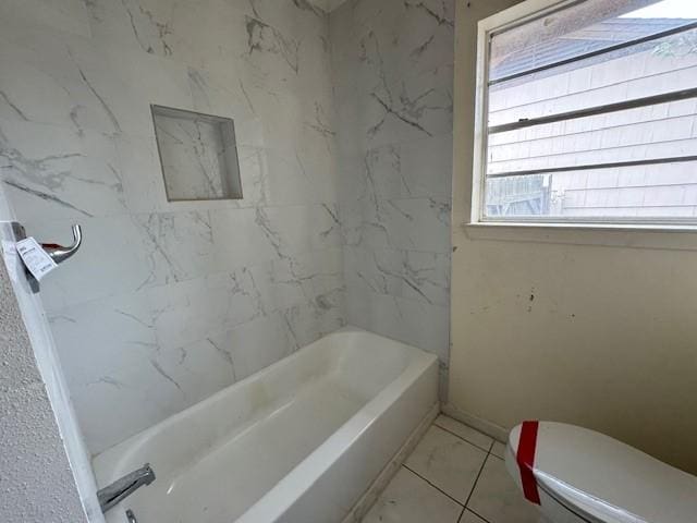 bathroom featuring a tub to relax in and toilet