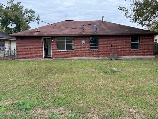 back of house featuring a yard and cooling unit