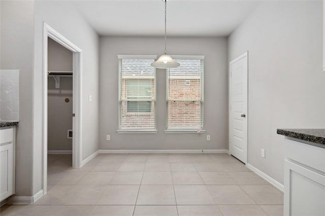 unfurnished dining area featuring light tile patterned flooring