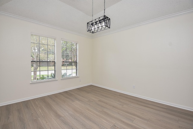 empty room featuring crown molding, a textured ceiling, and hardwood / wood-style flooring