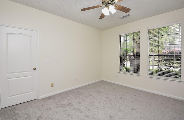 carpeted spare room featuring ceiling fan and a textured ceiling