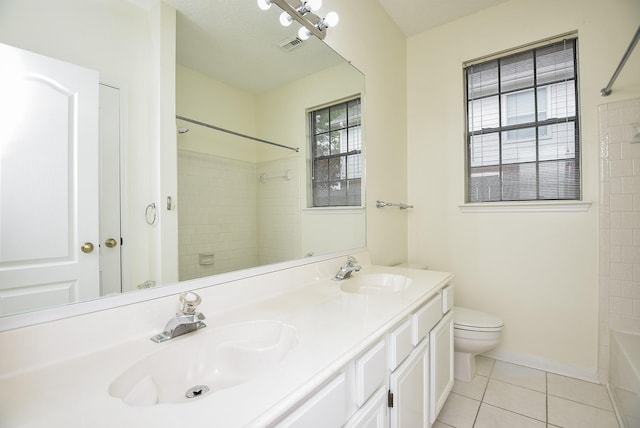 full bathroom featuring tile patterned floors, vanity, a textured ceiling, tiled shower / bath combo, and toilet