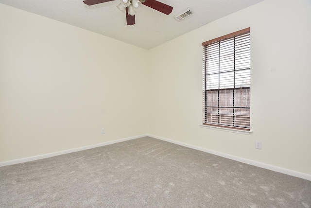 carpeted empty room featuring ceiling fan and a textured ceiling