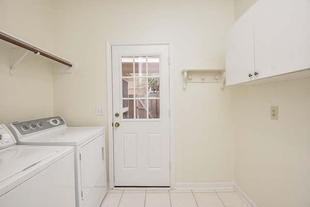 laundry area with washer and clothes dryer, light tile patterned floors, and cabinets