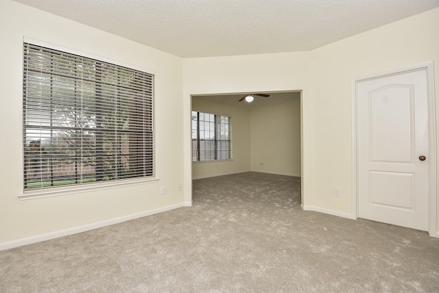 carpeted empty room featuring a textured ceiling